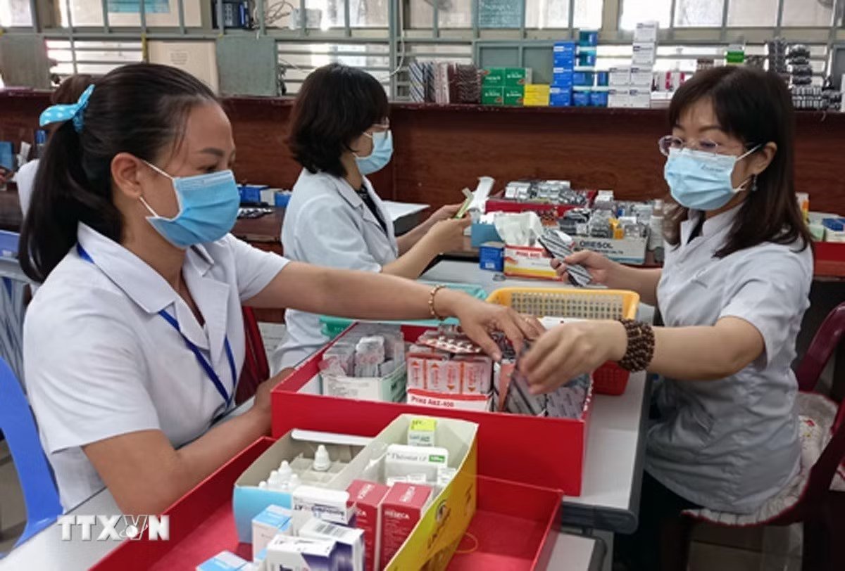 Nhân viên y tế chuẩn bị thuốc để cấp cho bệnh nhân điều trị ngoại trú có tham gia Bảo hiểm Y tế