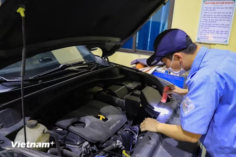 Kỹ thuật viên kiểm tra khoang động cơ tại cơ sở đăng kiểm