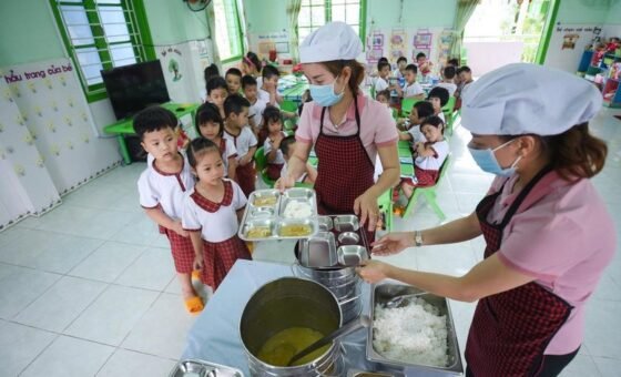 Nhân viên chuẩn bị bữa ăn cho học sinh tại trường học