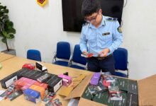 Cán bộ quản lý thị trường kiểm tra hàng hóa được bày trên bàn