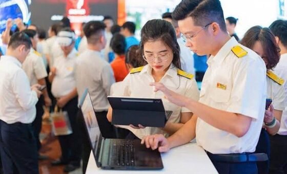 Người dân trao đổi với cán bộ và sử dụng thiết bị số tại quầy hỗ trợ